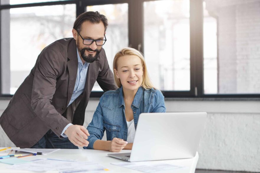 Image of talented female and male coworkers search information in network for future startup project, use presentation, plans work schedule or make online conference with partners. Cooperation concept